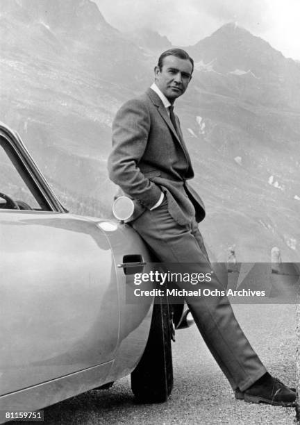 Actor Sean Connery poses as James Bond next to his Aston Martin DB5 in a scene from the United Artists release 'Goldfinger' in 1964 Photo by Michael...