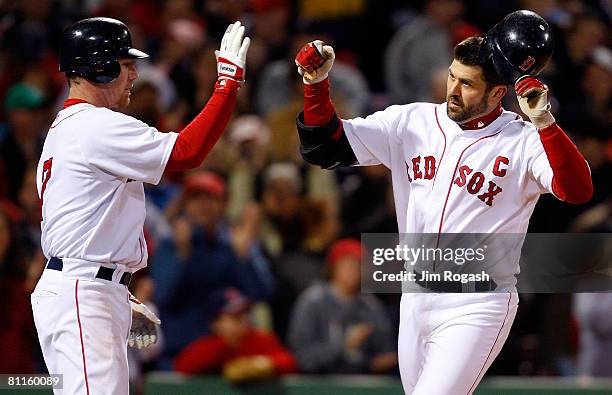 Jason Varitek of the Boston Red Sox is congratulated by teammate J.D. Drew after hitting a home run against the Kansas City Royals at Fenway Park on...