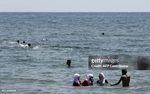 Syrians take a dip in the Mediterranean Sea in the northwestern city of Latakia on July 7, 2017. A popular seaside resort largely untouched by the...