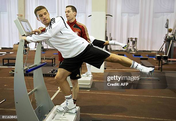 German striker Lukas Podolski attends a fitness training session under they eyes of fitness coach Oliver Schmidtlein with the German national...