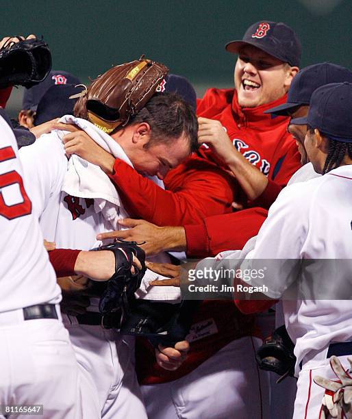 Jon Lester the Boston Red Sox is congratulated by Jonathan Papelbon and other teammates after throwing a no hitter against the Kansas City Royals at...