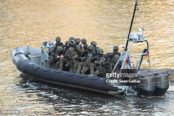 Havily-armed unit of the German police ride a boat in a waterway near the Elbphilharmonie philharmonic concert hall while leaders and their spouses...