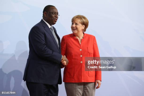 German Chancellor Angela Merkel greets Senegal Presidentt Macky Sall upon his arrival for the first day of the G20 economic summit on July 7, 2017 in...