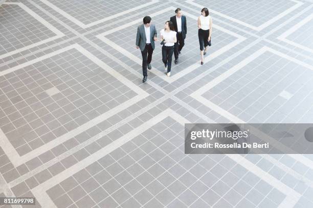 business people walking through japanese office foyer, overhead view - four people business talking stock pictures, royalty-free photos & images