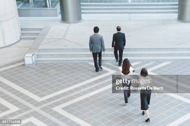 business people walking through japanese office foyer, overhead view - four people walking away stock pictures, royalty-free photos & images