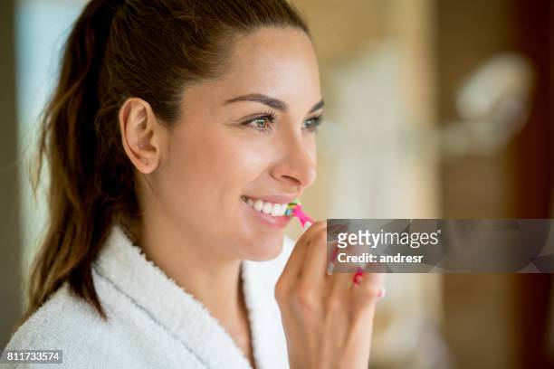 porträt einer frau in das bad putzen ihre zähne - zähne putzen frau stock-fotos und bilder