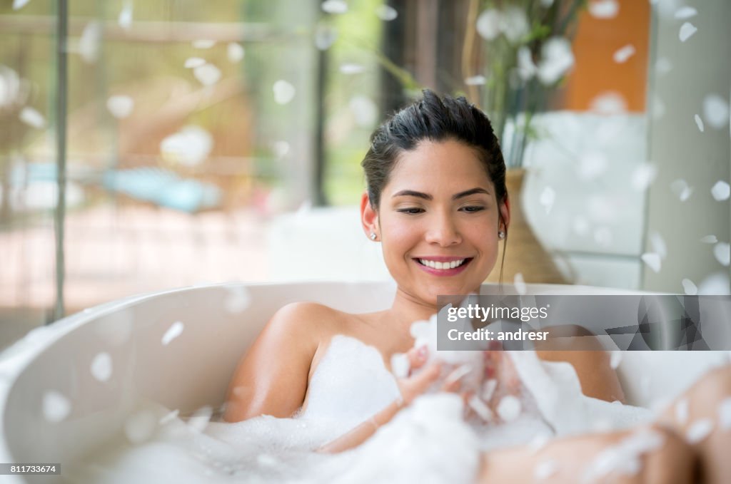 Mooie vrouw thuis ontspannen met een bubbelbad