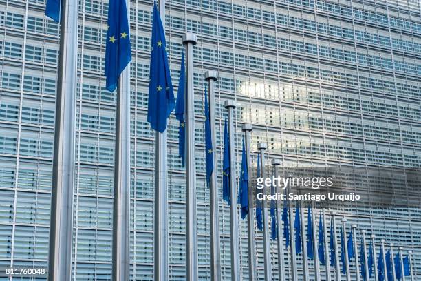 european union flags at berlaymont building of the european commission - berlaymont stockfoto's en -beelden