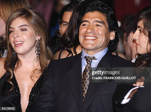 Former Argentinian football player Diego Maradona poses with his daughters of Dalma and Giannina as he arrives to attend the screening of Serbian...