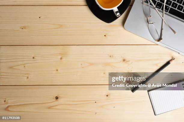 wooden surface diy table top view with office articles, laptop, tea cup - aerial view desk stock pictures, royalty-free photos & images