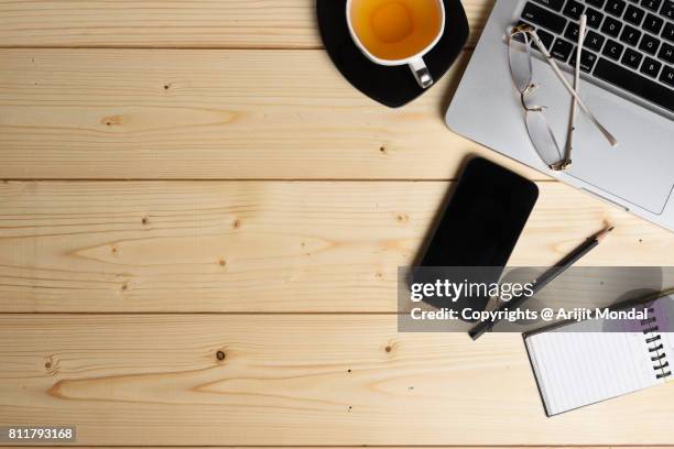 directly above shot of smart phone, green tea cup, laptop and office supplies - desk aerial view stock pictures, royalty-free photos & images