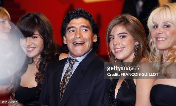 Former Argentinian football player Diego Maradona applauds as he arrives with his wife Claudia and daughters Dalma and Giannina to attend the...