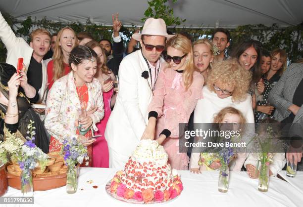 Robert Montgomery and Greta Bellamacina cut the cake surrounded by guests at their wedding on July 8, 2017 in Exeter, England.