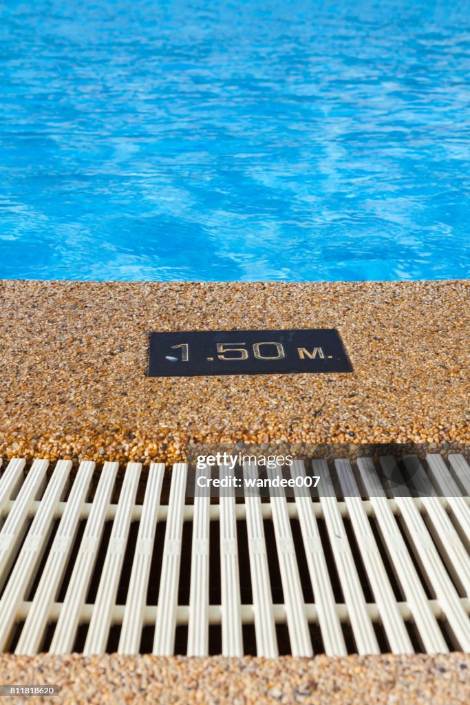 Pool depth sign at the edge of the swimming pool