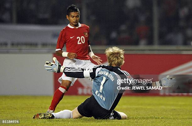 German league and Cup champions Bayern Munich goalkeeper and captain Oliver Kahn foils an attempt by Bambang Pamungkas of Indonesia during a friendly...