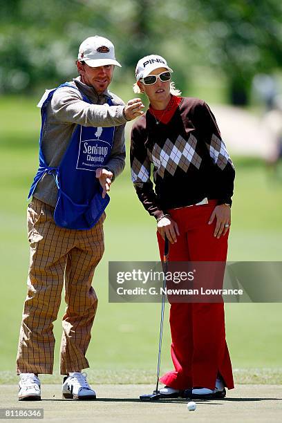 Carin Koch of Sweden talks with her caddie prior to a putt on the 9th hole during the second round of the SemGroup Championship presented by John Q....