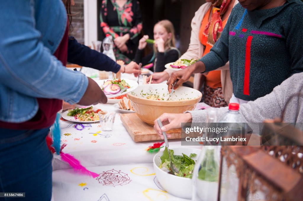 Girls and women serving food at a birthday dinner party