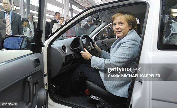 German Chancellor Angela Merkel inspects a Volkswagen car during a visit to the VW plant in Sao Bernardo do Campo, southern Sao Paulo on May 15,...