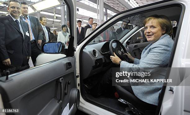 German Chancellor Angela Merkel inspects a Volkswagen car during a visit to the VW plant in Sao Bernardo do Campo, southern Sao Paulo on May 15,...