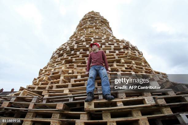Bonfire builder Ryan Preston poses for a photograph on the Doonbeg bonfire in Rathcoole in north Belfast, Northern Ireland on July 10 ahead of the...