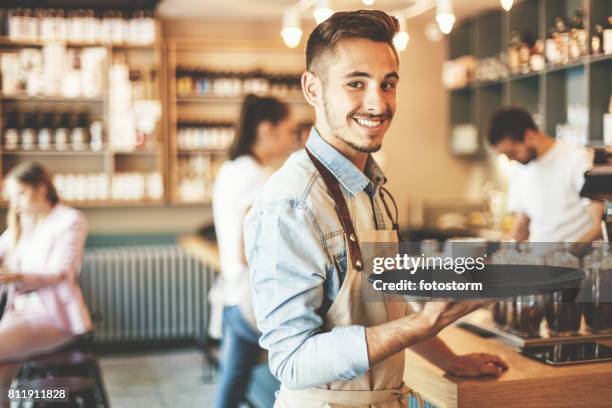 young waiter serving - travessa imagens e fotografias de stock