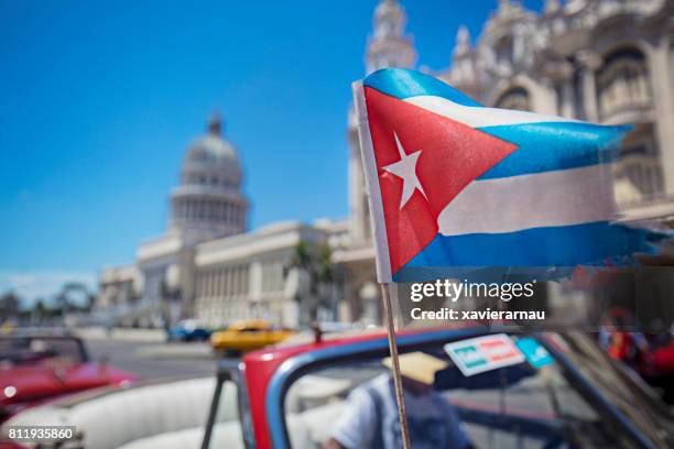 cuban flag in motion against capitolio - cuba stock pictures, royalty-free photos & images