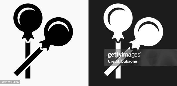 lollipop icon on black and white vector backgrounds - cake pop icon stock illustrations