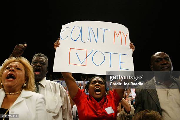 People cheer and a woman holds a sign reading "Count My Vote" as Democratic presidential hopeful U.S. Sen. Hillary Clinton speaks during a campaign...