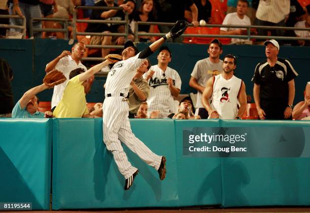 Third baseman Jorge Cantu of the Florida Marlins battles with fans as he over-runs a foul ball against the Arizona Diamondbacks at Dolphin Stadium on...