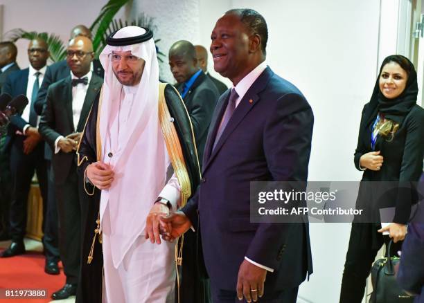 Ivory Coast President, Alassane Ouattara and Secretary-General of the Organisation of Islamic Cooperation , Yousef bin Ahmad al-Othaimeen hold hands...