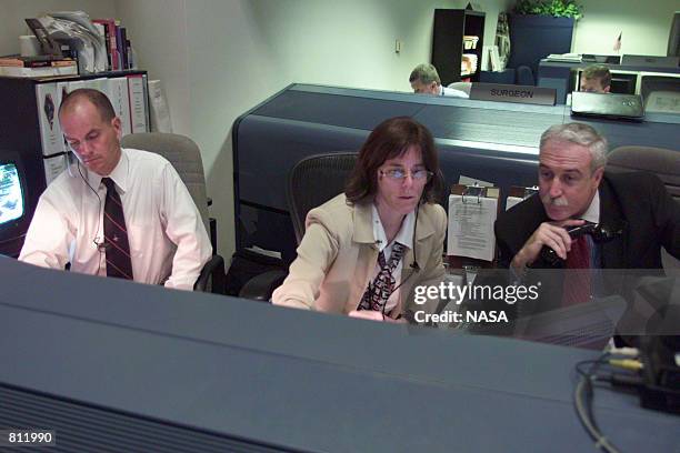 Astronaut Barbara Morgan , a former teacher, sits at the console to overview STS-110 flight information as she is accompanied by NASA Administrator...