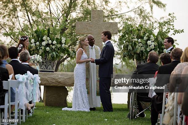 In this handout image provided by the White House, Henry Hager and Jenna Bush exchange vows at the altar at Prairie Chapel Ranch as Rev. Kirbyjohn...