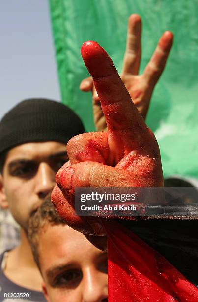 Protester holds a blood-soaked Palestinian flag during a demonstration against the blockade on Gaza, on May 22, 2008 at the Karni Crossing, Gaza. At...