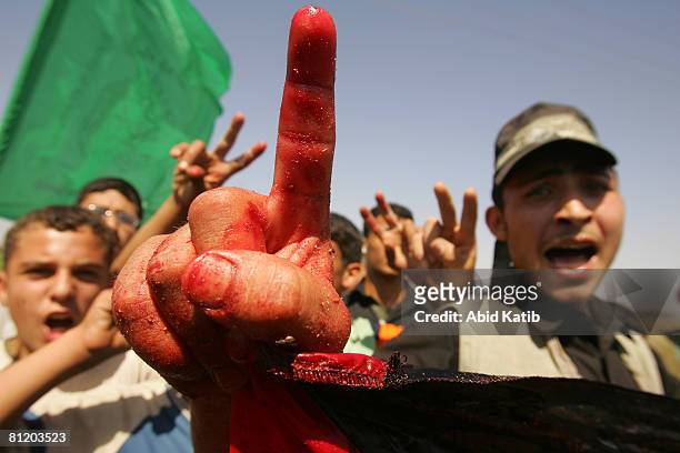 Protester holds a blood-soaked Palestinian flag during a demonstration against the blockade on Gaza, on May 22, 2008 at the Karni Crossing, Gaza. At...
