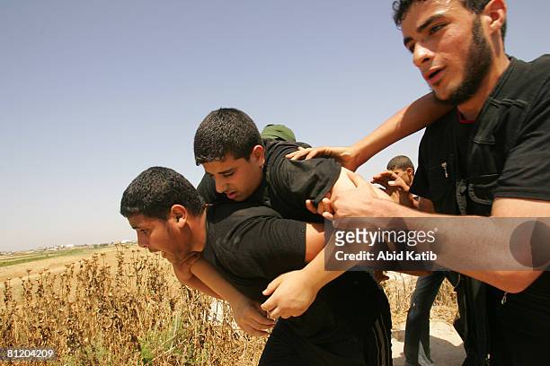 Wounded Palestinian youth is carried by protesters after being wounded by Israeli Defense Forces during a demonstration against the blockade on Gaza,...
