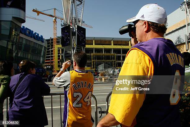 Los Angeles Lakers fans use binoculars to see the red carpet for the season seven finale of 'American Idol' at the Nokia Theatre before the Lakers...