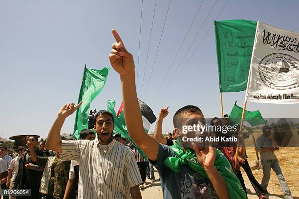 Palestinian protestors hold Hamas flags and shout slogans during a demonstration against the blockade on Gaza, on May 22, 2008 at the Karni Crossing,...