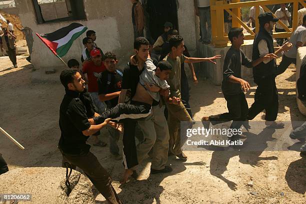 Young wounded Palestinian boy is carried by protesters after being wounded by Israeli Defense Forces during a demonstration against the blockade on...