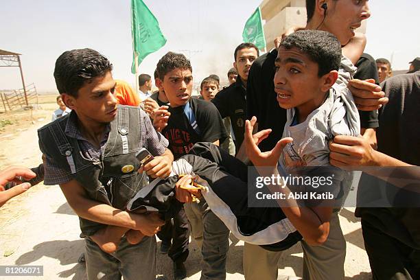 Young wounded Palestinian boy is carried by protesters after being wounded by Israeli Defense Forces during a demonstration against the blockade on...