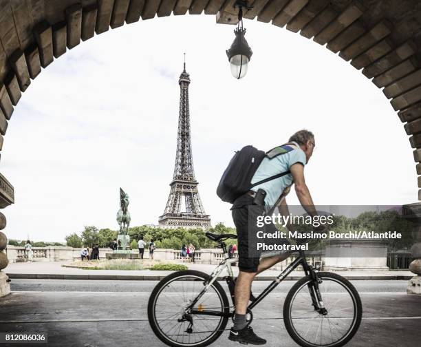 pont de bir-hakeim (formerly the pont de passy), man riding bicycle along the bicycle lane of the viaduc de passy - bicycle lane stock-fotos und bilder