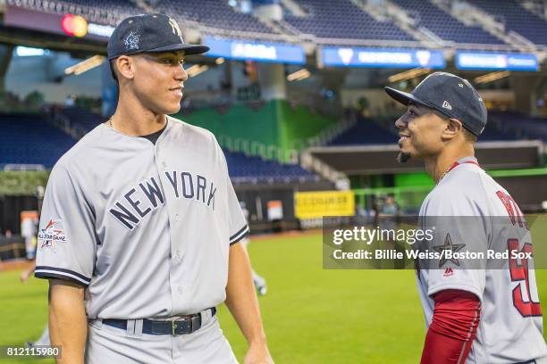 Aaron Judge of the New York Yankees talks with Mookie Betts of the Boston Red Sox during Gatorade All-Star Workout Day at Marlins Park on July 10,...