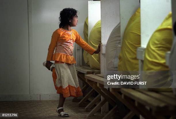 An Iraqi girl stands beside her father during his visitation time with his family inside the Camp Bucca detention centre located near the Kuwait-Iraq...