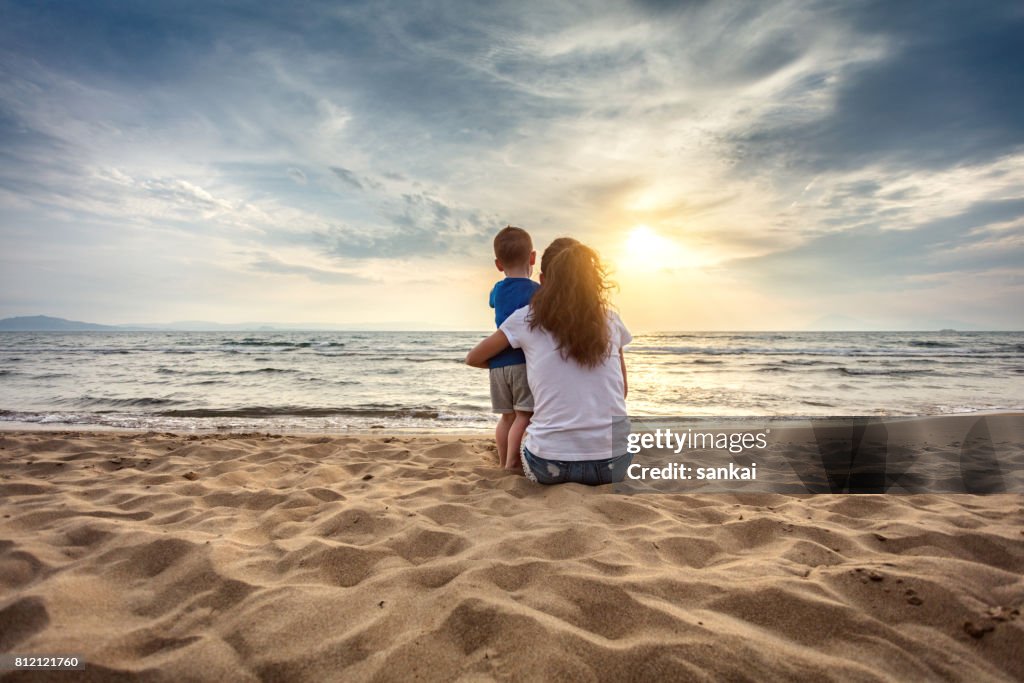 Mother with son enjoying sunset on the beach