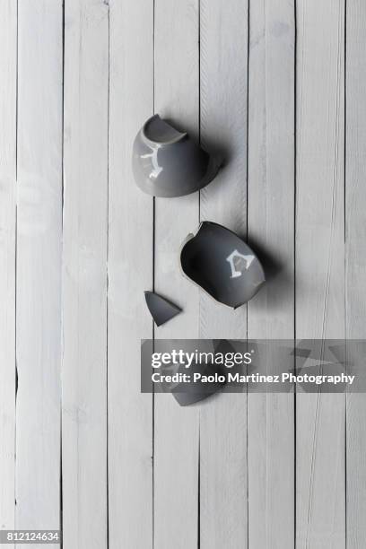 broken mug on a wooden background - broken cup stock-fotos und bilder