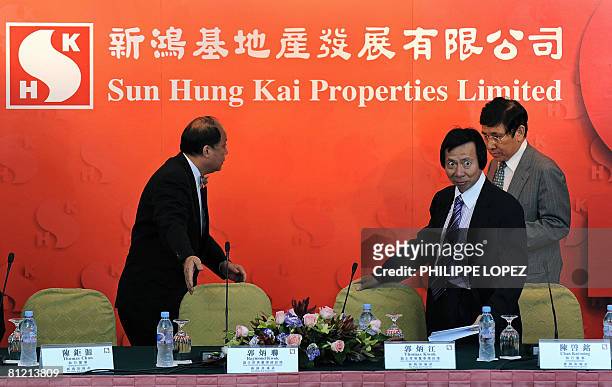 Raymond and Thomas Kwok, both vice chairmen and managing directors of Sun Hung Kai properties, arrives at a press conference in Hong Kong on May 23,...