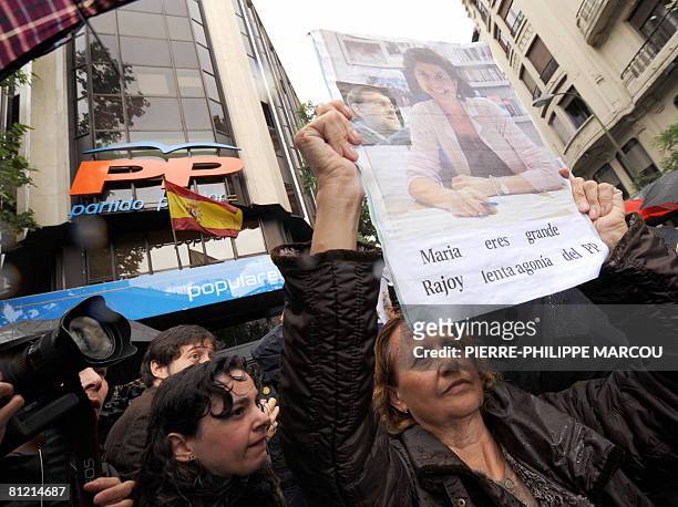 Woman supporting Basque Popular Party leader Maria San Gil holds a placard saying "Maria you are great -- Rajoy Slow Agony of the PP" in front of...