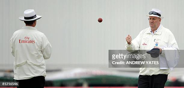 Umpire Darrell Hair passes the ball to fellow umpire Simon Taufel during the first day of the second test match at Old Trafford, Manchester,...