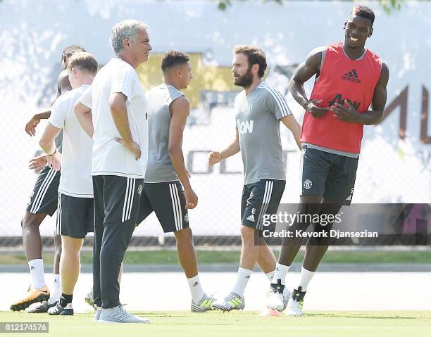 Paul Pogba of the Manchester United runs with manager Jose Mourinho looking on during a training session for Tour 2017 at UCLA's Drake Stadium July...