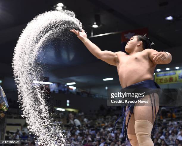 Terutsuyoshi, a juryo wrestler, sprinkles salt on the dohyo ring ahead of a bout at the Aichi Prefectural Gymnasium on July 9 the first day of the...