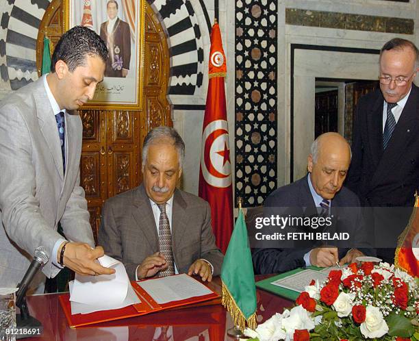 Tunisian Prime minister Mohamed Ghannouchi and with his Libyan counterpart, Secretary of the General People's Committee Baghdadi Al-Mahmudi, sign an...